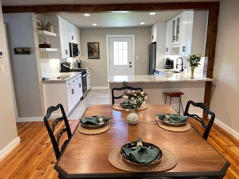Living room and view of kitchen.  Door leads to back deck and river
