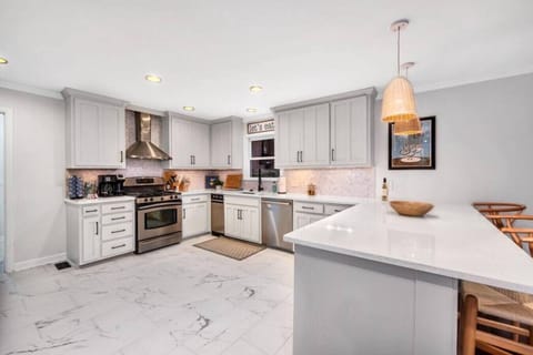 Kitchen fully stocked with all cooking essentials, oven, bar area, dishwasher, microwave, stove and drop coffee maker