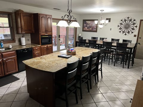 Open kitchen with granite island and four counter height chairs.