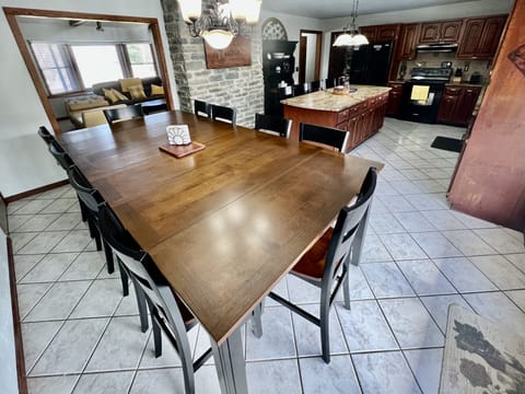 Open concept dinning room with cherry table that seats 10 people