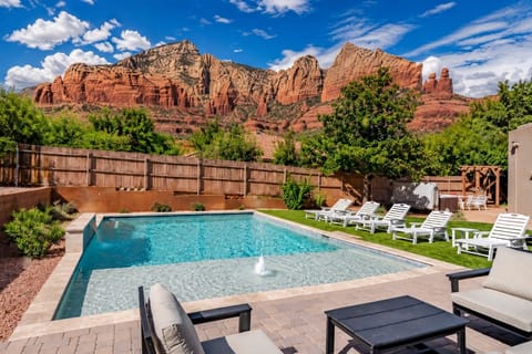 Glowing red rock views from the backyard oasis, complete with pool loungers and water features