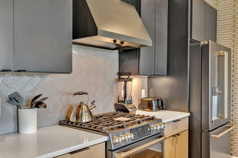 Modern sleek kitchen stocked with your basic cooking essentials. Complete with stainless steel appliances and breakfast bar seating.