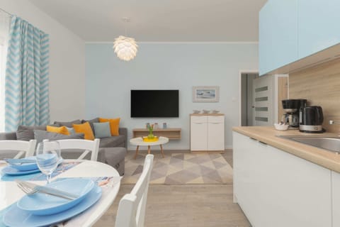 A dining table set for four, complete with elegant blue tableware and a centerpiece of fresh flowers. The striped wallpaper adds a touch of sophistication.