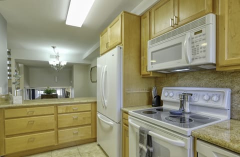A modern electric range, large microwave and oversized refrigerator/freezer accommodate family dining and leftovers.