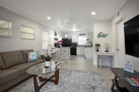 Open floor plan living room, kitchen and dining area. A small desk is provided.