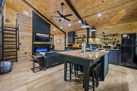 Open living area featuring kitchen island and ladder-accessible loft