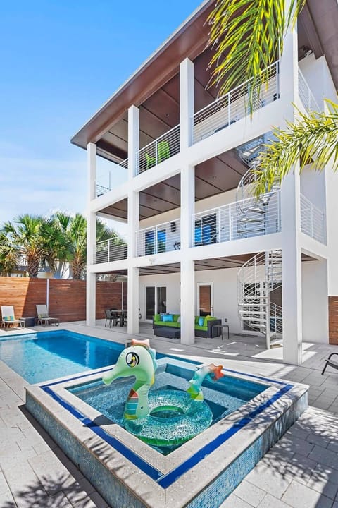 Stunning sparkling blue pool with hot tub and patio seating.