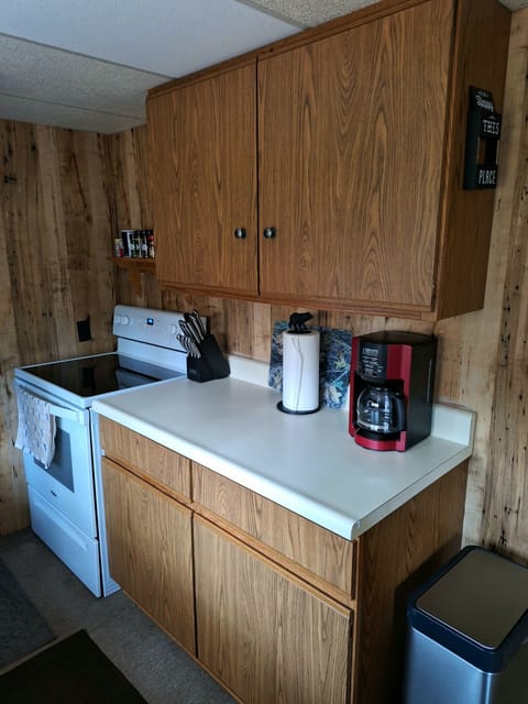 Kitchen with new appliances. Plenty of dishes, glasses, silverware, pots & pans.