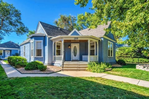 Welcome to Our Charming Guesthouse and Historic Home, Nestled in a Picturesque Setting with a Well-Manicured Yard and Inviting Sidewalk.