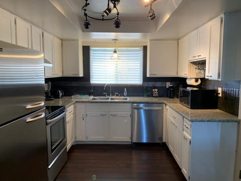The kitchen with granite counter tops and new appliances.