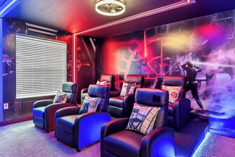 Relax in our cozy home theater featuring stylish black and blue recliners, perfect for watching your favorite films. The vibrant wall art and ambient lighting set the stage for unforgettable movie nights with friends and family.