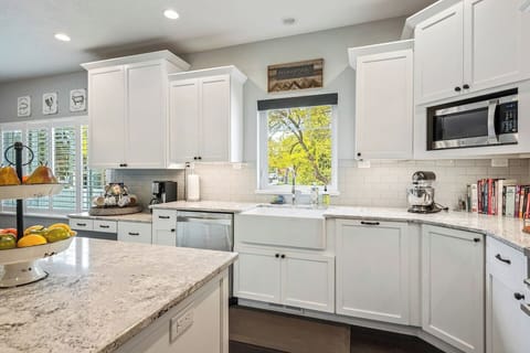 9. Modern kitchen w/ granite countertops, and a subway tile backsplash.