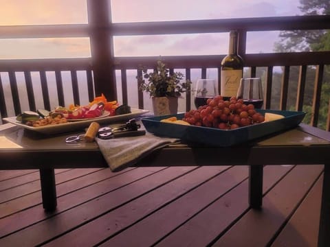 Enjoy a cozy evening on the deck with wine and charcuterie, surrounded by nature and serene views.