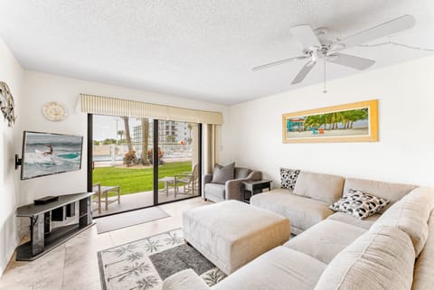 Spacious living room with comfortable couch and large TV - walks out onto patio
