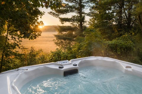 Nestled among the trees with views of open countryside, the hot tub is the perfect place to unwind after a day exploring Traverse City. ✨