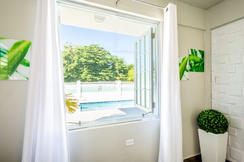 Living Room: Bright and airy space with vibrant decor and welcoming views of the gleaming pool!