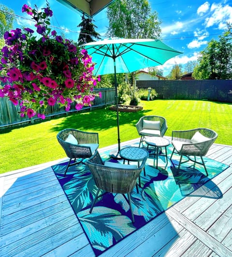 Inviting backyard deck with comfortable outdoor seating, and a patio umbrella.