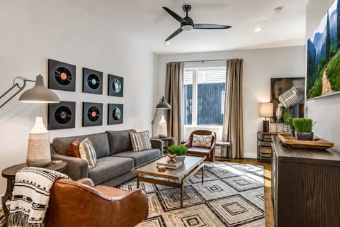 Retro-inspired living area with vinyl wall art and stylish seating, perfect for relaxing and gathering.