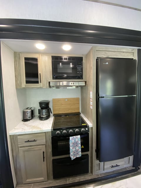 Kitchen amenities including dishes, cookware, cooking utensils, coffee pot etc