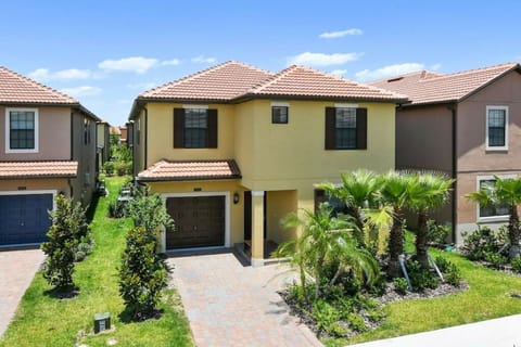 This charming vacation home, with its warm yellow exterior and dark shutters, creates a welcoming atmosphere. Lush palm trees and neat landscaping lead to a spacious driveway, ensuring easy access as you enjoy sunny days ahead.