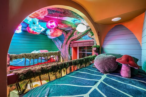 Magical bunk room. The forest canopy ceiling glows and shimmers with magical colors. Magical forest dreamscape: two queens and four XL twin beds. Plus a hobbit door!