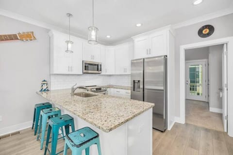 Fully stocked kitchen with pots and pans. Fridge has water/ice dispenser