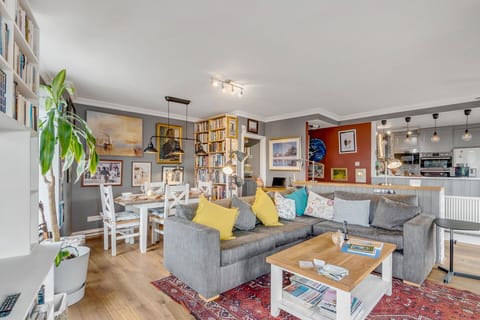 Living room with a large L shape sofa, coffee table, stairs to the Private rooftop garden, bookshelves full of books and Large Smart TV with Netflix.
you also have 4 large windows with panoramic views of the city and the best sunsets in Norwich.
In the corner, there is an indoor fireplace for romantic cosy evenings, we provide you with everything that you need to start a fire...