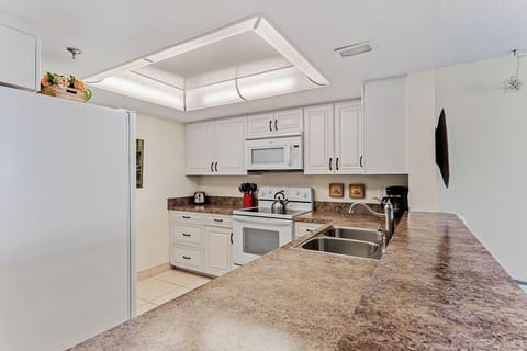 Your fully equipped kitchen features granite countertops, white cabinetry, and modern appliances perfect for preparing meals during your stay.