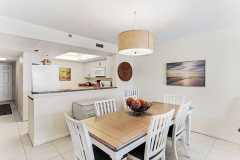 Your bright dining space flows seamlessly into the modern kitchen, perfect for memorable meals together under warm pendant lighting.