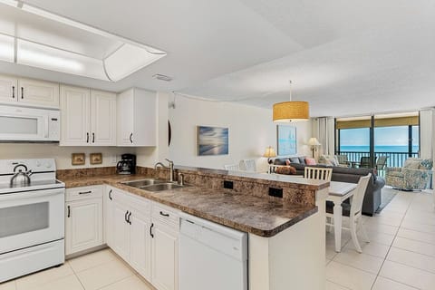 Your modern kitchen opens to the living area with stunning sea views through floor-to-ceiling windows.