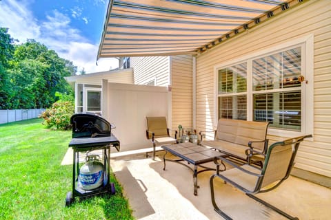 Outdoor patio with grill, seating, and covered awning.