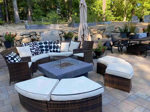The spectacular two tiered oversized stone patio creates a standout outdoor living experience, with fire tables, expansive seating, and beautifully designed spaces for relaxing, entertaining, and enjoying the Hampton Beach air.