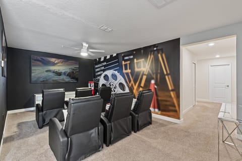 Enjoy a cinematic experience in our stylish media room, complete with plush black recliners and a captivating wall mural. Soft carpeting and ambient lighting set the perfect cozy atmosphere for your movie nights.