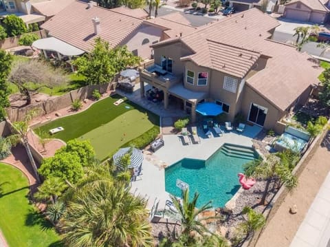 Aerial view showcasing this stunning property with its sparkling pool, manicured lawn, and spacious outdoor entertaining areas in a quiet residential neighborhood.