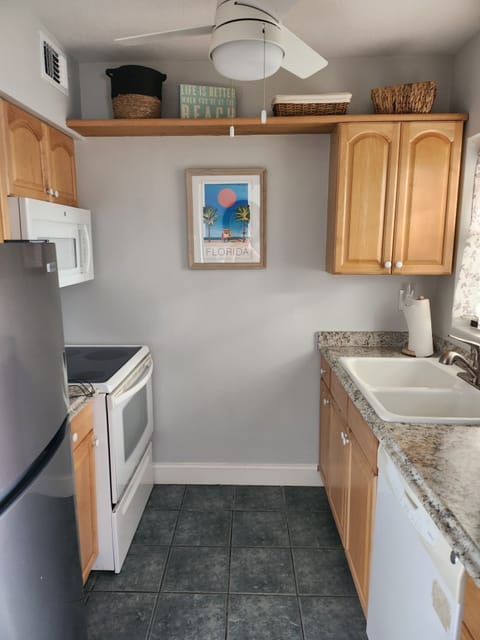 Full galley-style kitchen. Cabinet space, dishes and glassware, cookware.