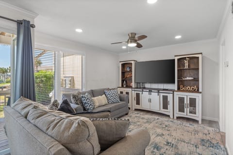 Sink into plush seating and unwind as you stream your favorite shows on the large TV, all while enjoying breezes from the ceiling fan and natural light streaming through nearby windows.