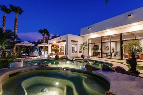 Luxury resort style backyard with heated pool, spa, fire pit, and putting green 