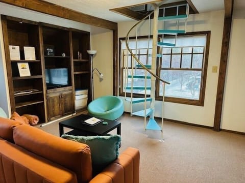 Living Room with spiral staircase up to the bedroom