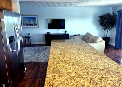 Newly renovated kitchen with large granite countertop and 4 bar stools. 