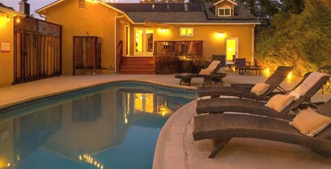 Cozy poolside escape with glowing string lights and comfy loungers - perfect for relaxing evenings under the stars.
