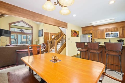The dining room table can accommodate six, with seating for four more at the bar area that serves as an ideal bridge between the kitchen and dining areas, allowing for easy serving and socializing thanks to the open layout of this home.