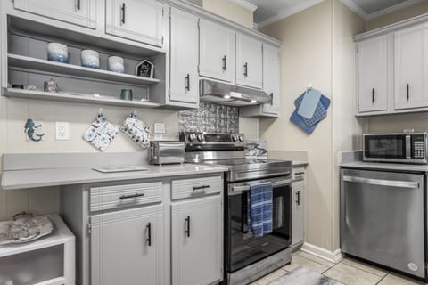 Fully stocked kitchen with drinkware, plates, flatware and cookware. 