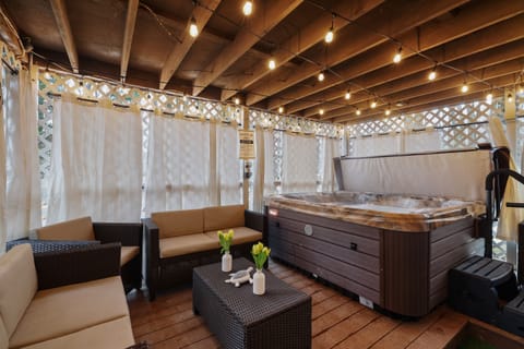 This covered area boasts a relaxing hot tub, perfect for unwinding after a long day. The peaceful ambiance created by the soft lighting and protection from the elements makes it a cozy space to rejuvenate. With its serene setting, this covered area with a 