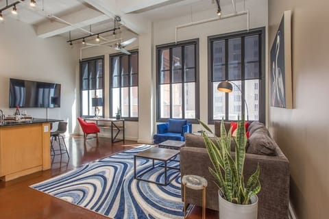 Relax in this cozy, modern living room featuring chic décor, comfortable seating, and warm lighting that creates the perfect ambiance for unwinding in the heart of downtown Fort Worth.