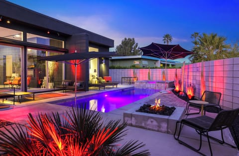 Colorful evening pool scene with fire pit and mountain silhouettes