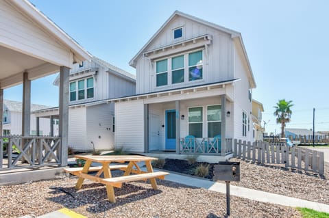 Charming coastal home featuring picnic table and gravel landscaping, perfect for outdoor dining and relaxation.