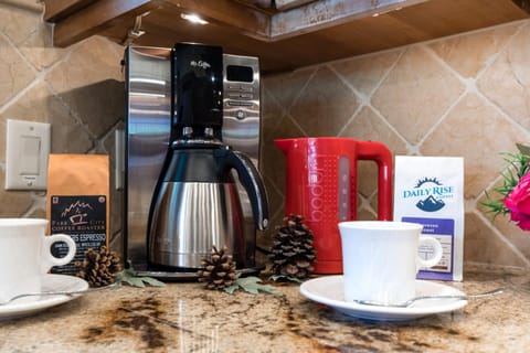 Coffee station with fresh brew, mugs, and rustic pinecone decoration. PLO-6599