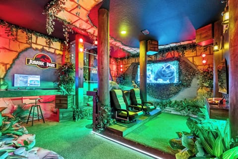 Experience a whimsical adventure in this vibrant entertainment room, featuring lush greenery and striking neon lighting. Enjoy immersive movie nights on cozy seating, surrounded by themed decor that takes you to another world.