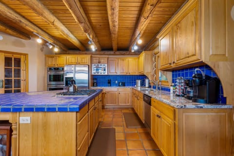 Fully stocked kitchen with a blender, coffee pot, toaster, ice maker, double oven, microwave, pots, pans, dishes, utensils, and plenty of space to feed a crowd.