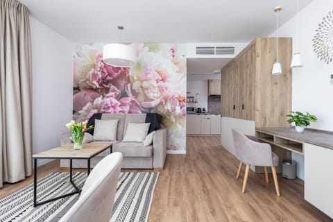 The elegant living room featuring a double sofa bed and a desk.